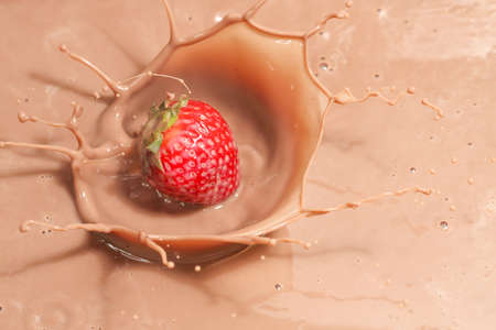 strawberry splashing into chocolate milk