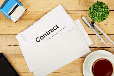 envelope with contract on wooden desk, top viewの写真素材