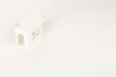 white cardboard house on white surface, abstract house conceptの写真素材