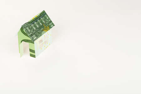 house wrapped in euro banknote on white surfaceの写真素材