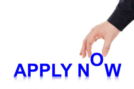 male hand placing letters to form the words apply nowの写真素材