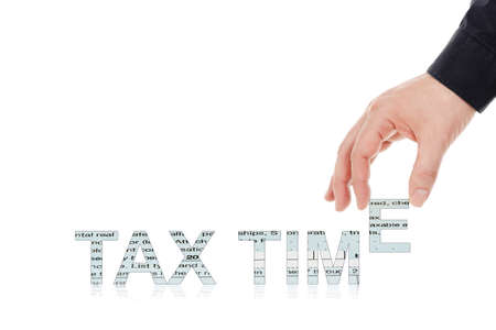 male hand placing letters to form the words tax timeの写真素材