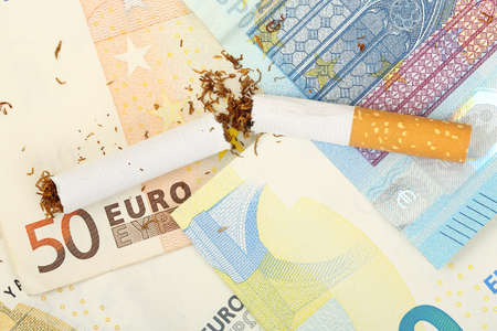 broken cigarette on euro banknotes, smoking is expensiveの写真素材