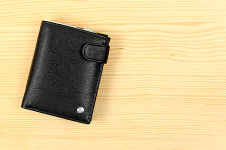 black leather wallet on wooden desk surfaceの写真素材