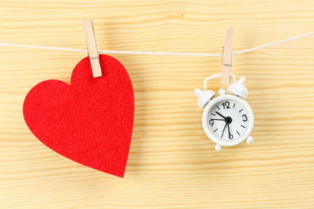 red felt heart and clock on clothesline, time for love conceptの写真素材