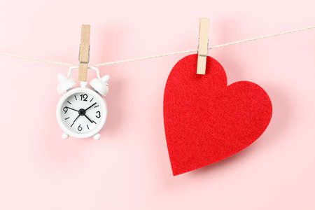 red felt heart and clock on clothesline, time for love conceptの写真素材