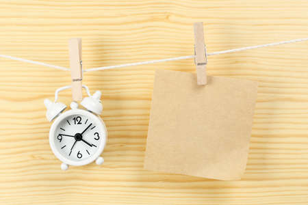 Clock and blank note on a clothes lineの写真素材