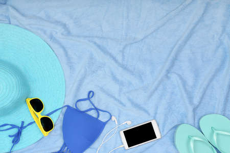 top view of blue towel with beach accessories and copy spaceの写真素材