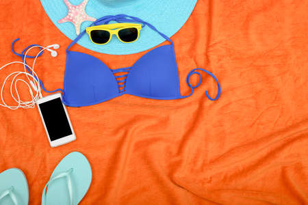 essential items for the beach on orange towel with copy spaceの写真素材