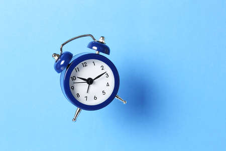 single alarm clock on blue backgroundの写真素材
