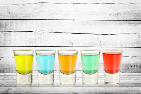 close up of five colorful shots on weathered wood