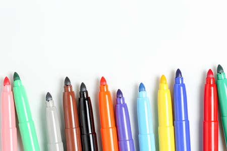 colorful markers closeup on white surface with copy space