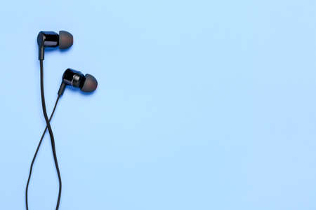 modern earphones on cyan surface with copy spaceの写真素材