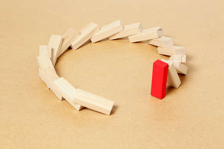 red toy block refusing to fall, abstract leadership or different conceptの写真素材