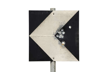 bullet holes on weathered road sign with arrowの写真素材