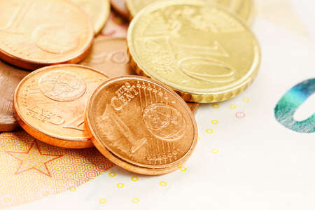 close up of euro coins on euro banknote