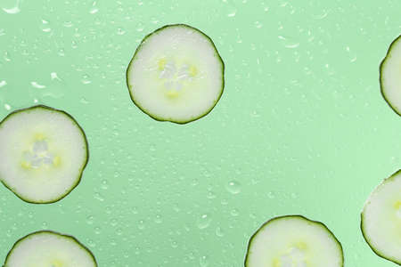 cucumber slices on glass with water dropsの写真素材