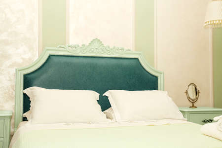 luxurious bedroom with antique bed and bedside tables, decorated wallの写真素材