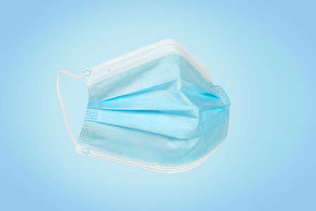 Disposable medical mask isolated on blue
