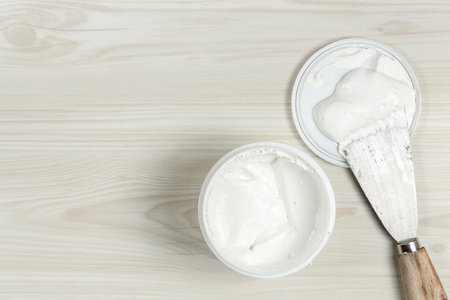 spatula and tub of white putty, top view with copy spaceの写真素材
