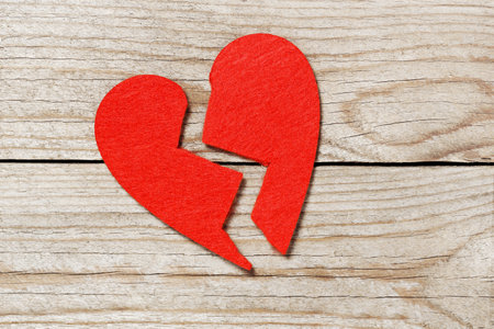 torn in two red love heart on old wooden planksの写真素材