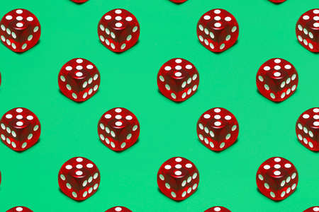 red transparent dice on green plastic surfaceの写真素材