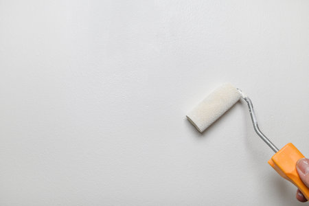 hand with roller painting a wallの写真素材