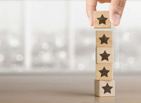 Hand arranging wooden blocks with the five star symbol.の写真素材