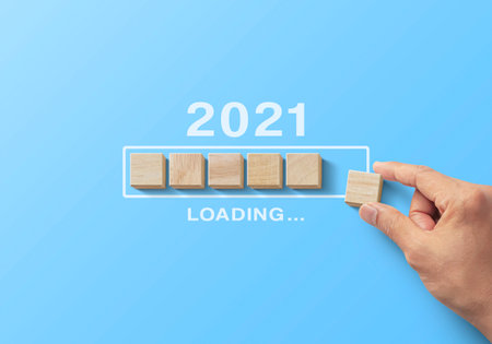 Hand putting wooden blocks in progress bar on blue
