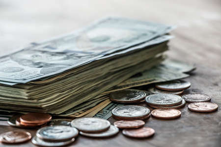 Financial, banking or savings concept. Dollar banknotes and coins on wood desk background with copy space.の写真素材