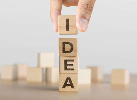 Hand arranging wooden blocks with the word IDEA. Idea, Creative, solution or problem solving concept.の写真素材