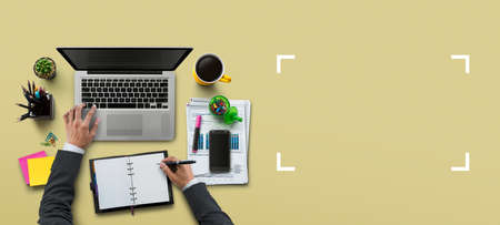 Office workplace with laptop, notebook, hand, office supplies, on khaki background. Solution, business planning, financial analysis, accounting, start up or working flat lay top view concept.の写真素材