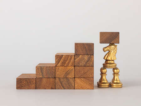 Teamwork to success in business or cooperation to success concept. Chess are cooperating to lift the...