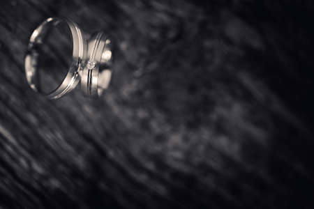Wedding rings on a textured wood backgroundの写真素材