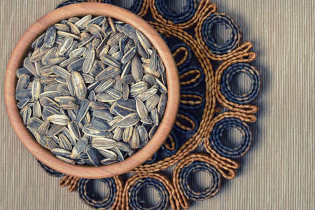 Seeds of sunflower placed in a wooden bowl with abstract background
