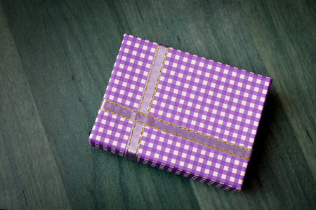 Purple gift box with green wooden background