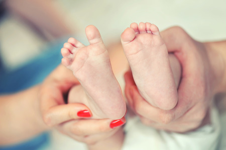 The legs of a new born in the hands of parentsの写真素材
