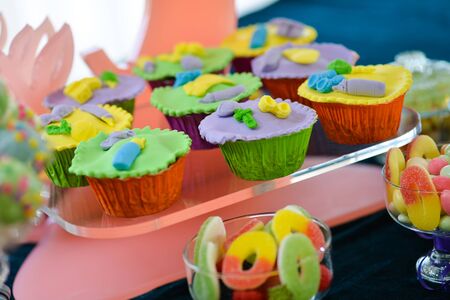 A lot of colorful cupcakes placed on a transparent shelfの写真素材