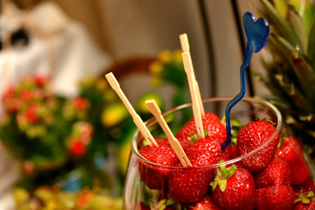 Fresh Strawberries with toothpicks stuck in them, placed in a glass bowlの写真素材