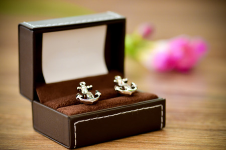Shirt cufflinks shaped boat anchor placed in supportの写真素材