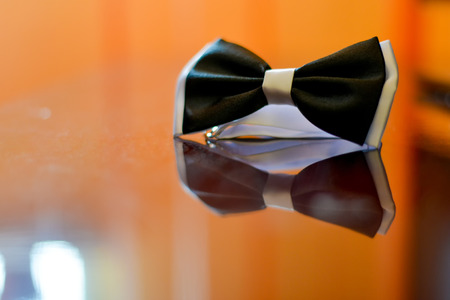 Black bow tie with gray edges on a reflexive surfaceの写真素材