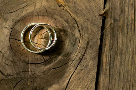 Gold wedding rings placed on a wooden textureの写真素材