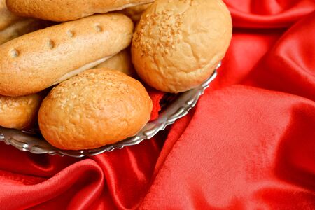 Bread placed in a metal basket on a red velvet surfaceの写真素材