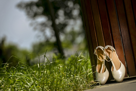 White bridal shoes against a wooden objectの写真素材
