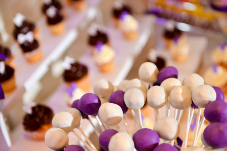 White and mauve lollipops with many cake in backgroundの写真素材