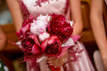 Bride holding a red flower bouquetの写真素材