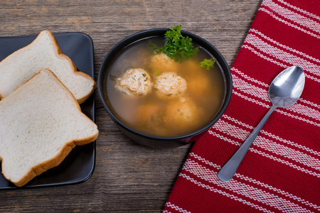 Meatball soup with bread on the table in natural lightの写真素材