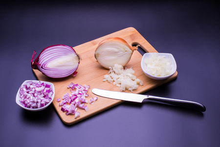 Red and white onion cut and all on a wooden bottom in black backgroundの写真素材