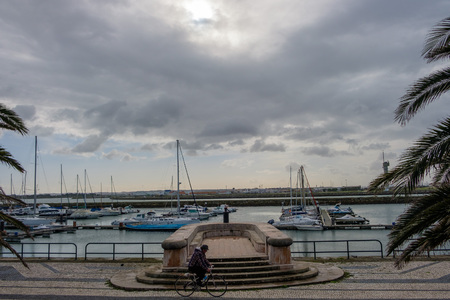 Figueira da Foz, Portugal - January 26, 2018: Local inhabitant cycling by the Marina, Portugalのeditorial素材