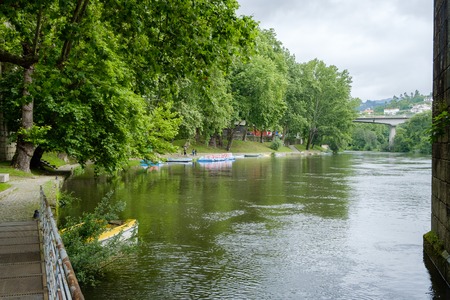 Amarante, Portugal - June 10, 2018 : On rainy day, pleasure boats are moored on the banks of the Tamega River Porto district, Portugalのeditorial素材